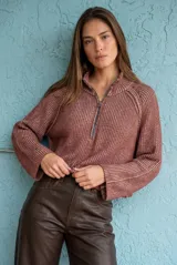 Sweater de punto acanalado en color camel, con cuello alto y cierre frontal parcial. Presenta mangas largas con diseño holgado y corte al cuerpo.