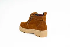 Bota acordonada de cuero gamuza color beige, con suela de goma dentada y forro interior a cuadros.