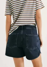 Short de jean de tiro medio, color azul oscuro, con diseño de corte curvo en los laterales y bolsillos frontales.