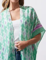 Kimono tejido con estampado abstracto en tonos azules, blancos y violetas. Tiene terminación de ruedo con borlas.