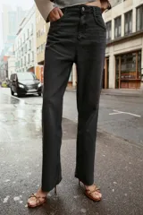 Jeans tobilleros de tiro alto, color negro lavado, con pernera recta y acabado sin costura en el ruedo. Modelo de cinco bolsillos con cierre frontal de cremallera y botón.