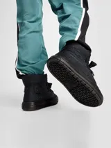 Bota de caña alta Converse estilo puffer, confeccionada en poliéster aislante y repelente al agua. Presenta diseño acolchado, cordones gruesos al tono y suela de goma reforzada. Incluye el parche clásico de la marca en el lateral.