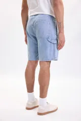 Bermuda de jean azul claro con lavado suave, bolsillos delanteros y traseros, y corte clásico de denim.