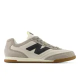 Championes New Balance modelo RC42, de estilo clásico y minimalista, con capellada en color crema y detalles en gris y azul marino. Presentan el logo "N" en el lateral y suela de goma color caramelo.