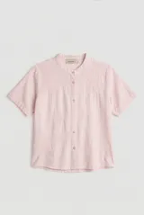 Camisa de manga corta color blanco con cuello mao y cierre frontal de botones. Presenta detalles bordados tono sobre tono en el canesú y diseño de corte recto.