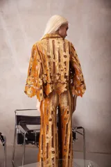 Camisa de corte oversize con mangas 3/4, confeccionada en una combinación de terciopelo y encaje con diseño floral. Presenta cuello clásico y una textura rica y elaborada.