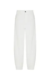 Pantalón de pana color blanco, corte balloon de talle alto y silueta ancha ligeramente ajustada en los tobillos. Cuenta con bolsillos y cierre frontal con botón y cremallera.