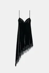 Vestido midi de terciopelo negro con escote en pico y tirantes finos ajustables. Presenta un diseño asimétrico en el bajo con aplicación de encaje a tono y espalda con tiras cruzadas.