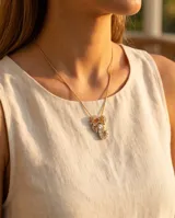 Collar de bronce dorado con cadena fina de eslabones y un dije en forma de cangrejo incrustado con circonias brillantes y piedras de colores en las pinzas.