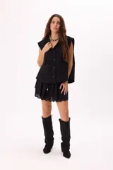 Minifalda marrón con volados de broderie, cintura elastizada con cordón ajustable y detalle de cuentas de madera.