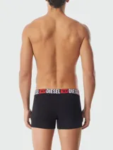 Boxer de algodón negro con cintura elástica ancha que presenta el logo de la marca Diesel en letras blancas y rojas.