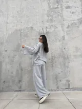Buzo oversize de color gris, con diseño de costuras expuestas en contraste y terminaciones desflecadas en mangas y ruedo.