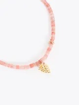 Collar corto realizado con cuentas de piedras naturales en tonos rosados, con dije colgante dorado en forma de fruta y cadena regulable.