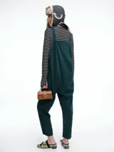 Mono largo de pana color verde oscuro, con breteles finos y silueta relajada de pierna amplia.