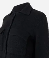 Campera de punto con textura, corte recto y cuello clásico. Presenta cierre frontal con botones y dos bolsillos aplicados con solapa en el pecho.