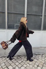 Jersey de punto color rojo vibrante, con cuello barco y manga larga. Presenta un calce amplio estilo capa con bajo asimétrico y aberturas laterales.