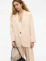 Blazer color durazno con pequeños lunares brillantes, cuello solapa, cierre con un botón frontal, bolsillos delanteros y corte clásico.