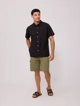 Bermuda cargo color verde oliva, con bolsillos laterales con solapa y botón a presión.