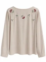 Blusa beige de manga larga con cuello redondo y delicados bordados florales dispersos en la parte superior del frente.