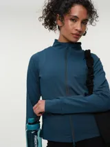 Campera deportiva marrón con cuello alto y cierre frontal completo. Presenta mangas largas con orificio para el pulgar y corte ajustado.