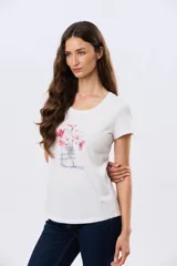Remera blanca de manga corta y cuello redondo, con estampa frontal de flores en tonos rosados dentro de un frasco de vidrio y detalles de letras bordadas.