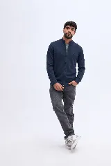 Campera de tejido liviano de algodón azul marino con cierre frontal, cuello alto y puños ajustados, con detalle de logo bordado en el pecho.