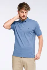 Remera polo de manga corta en tejido piqué color celeste. Presenta cuello clásico con botones, bordado pequeño en el pecho y detalles en tela oxford en el interior del cuello.