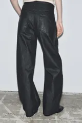 Jeans de tiro bajo con corte barrel leg y largo completo. Presentan un acabado craquelado, diseño de cinco bolsillos, trabillas en la cintura y cierre frontal con cremallera y botón metálico.