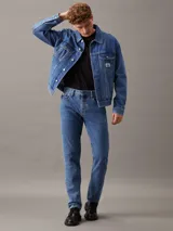 Remera de algodón de corte regular con cuello redondo y manga corta. Presenta un diseño minimalista con el logo de la marca estampado en pequeño en el pecho y un gráfico grande en la parte trasera.