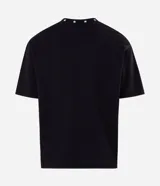 Remera boxy negra de algodón con cuello V decorado con pequeñas estrellas bordadas y un bordado numérico en el centro del pecho.