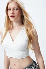 Top cropped negro con capucha, escote cruzado y calce ceñido.