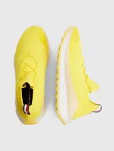 Zapatillas de running Tommy Hilfiger color amarillo, confeccionadas en tejido de punto elástico de poliéster reciclado, con cordones, suela dentada y plantilla de acupresión.
