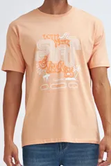 Camiseta de manga corta color salmón con estampado frontal estilo retro con temática de surf.