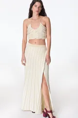 Falda larga color crema con lurex dorado, de tejido de punto acanalado y corte recto con abertura lateral.