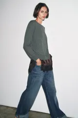 Jersey de punto liso color verde, con cuello redondo y manga larga. Confeccionado en lana suave.