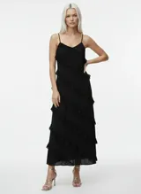 Vestido largo negro con tirantes finos ajustables y volantes diagonales.