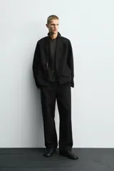 Blazer de corte relajado confeccionado en mezcla de algodón y lino. Presenta un diseño sin solapas, cierre frontal de un botón, manga larga y bolsillos ocultos en las costuras laterales. Interior sin forro.