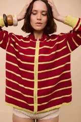 Campera de punto con cierre frontal, diseño de rayas horizontales en color bordó y amarillo mostaza, y textura ondulada en el tejido.