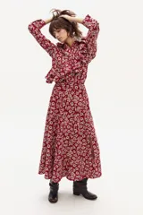 Falda larga con estampado floral en tonos rojo y beige, con tajo lateral y elástico en la cintura trasera.