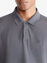 Chomba gris de piqué de algodón y poliéster, con cuello clásico abotonado, mangas cortas, corte regular y logo bordado en el pecho.