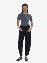 Pantalón de jean negro, tiro alto, de calce relajado y ancho en la parte superior, que se afina hacia el tobillo.