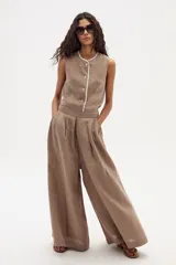 Pantalón palazzo color marrón claro, de tiro alto y confeccionado en lino.
