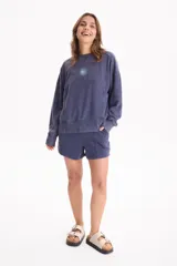 Short de felpa sin frisa con efecto acid wash color tostado, bolsillos laterales, tiro medio-alto, cintura elástica con cordón ajustable y costuras decorativas delanteras.