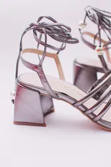 Sandalias doradas con taco cuadrado y tiras finas que se atan al tobillo. Capellada, forro y plantilla 100% de cuero.