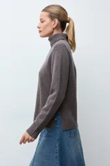 Polera de cuello alto en mezcla de cashmere, color marrón chocolate, con diseño de punto liso y costuras verticales decorativas en el frente.
