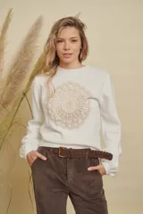 Buzo de punto color blanco con cuello redondo y detalle de mandala tejido en crochet en el centro del pecho.