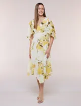 Vestido midi de gasa liviana con estampado floral en tonos amarillo y blanco, escote en V cruzado, mangas cortas amplias tipo capa, cintura entallada y falda con vuelo y ruedo irregular.