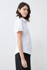 Camisa blanca de corte clásico, con cuello y mangas cortas.