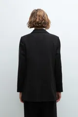 Blazer negro con bordado en contraste a lo largo de las mangas.