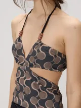 Top halter estampado en tonos rojo y beige, con tirantes finos ajustables al cuello y detalle de cuentas.